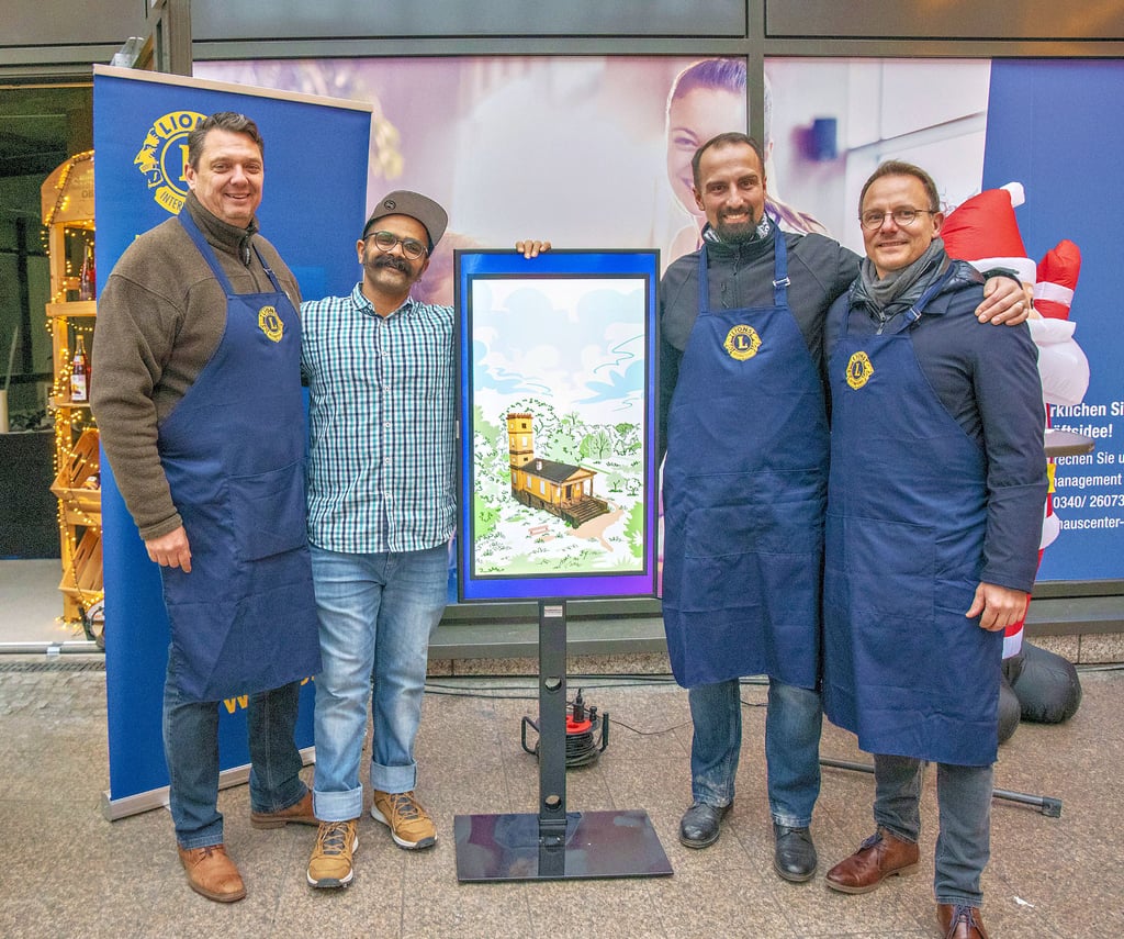Das erste Dessau Monopoly-Motiv mit dem Weinbergschlösschen präsentierten der Grafiker Harsh Pandya (2.v.li.), sowie die Mitglieder des Lions Club Dessau Tobias Gröger, Kenneth Hädecke und Andreas Hofmann auf dem Adventsmarkt.