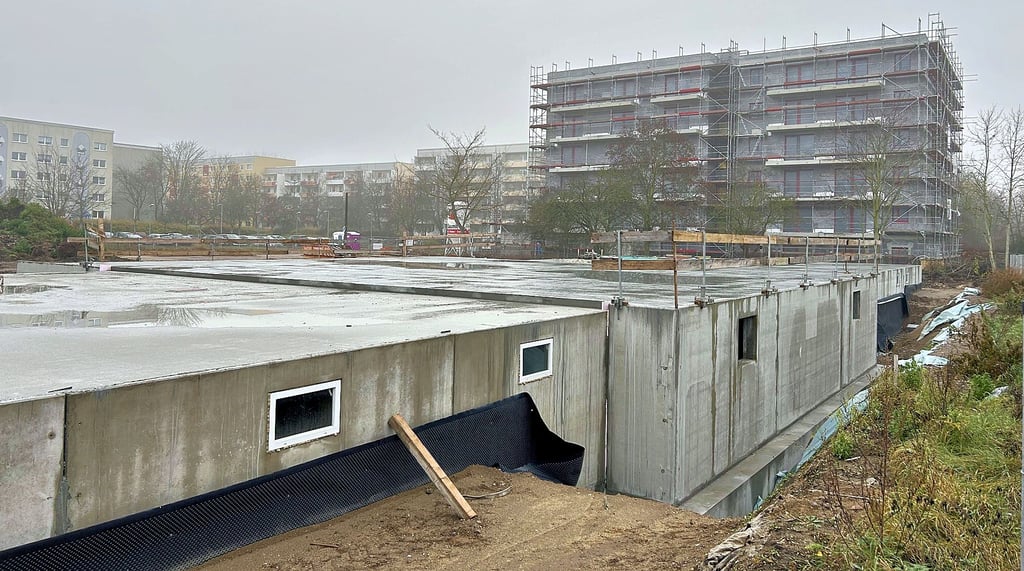 Die Bauarbeiten für die drei Mehrfamilienhäuser laufen seit Juni dieses Jahres in Magdeburg-Olvenstedt. Die Baustelle im Hintergrund zeigt den Wohnkomplex mit Pflegeangebot, der im dritten Quartal 2025 bezugsfertig sein soll.