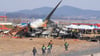 Feuerwehrleute und Rettungskräfte suchen am Wrack des verunglückten Flugzeugs auf dem internationalen Flughafen von Muan nach Opfern.