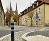 Ein Poller schützt die zur Fahrbahn weisende Kante der Bank am Bachdenkmal in der Schulstraße.