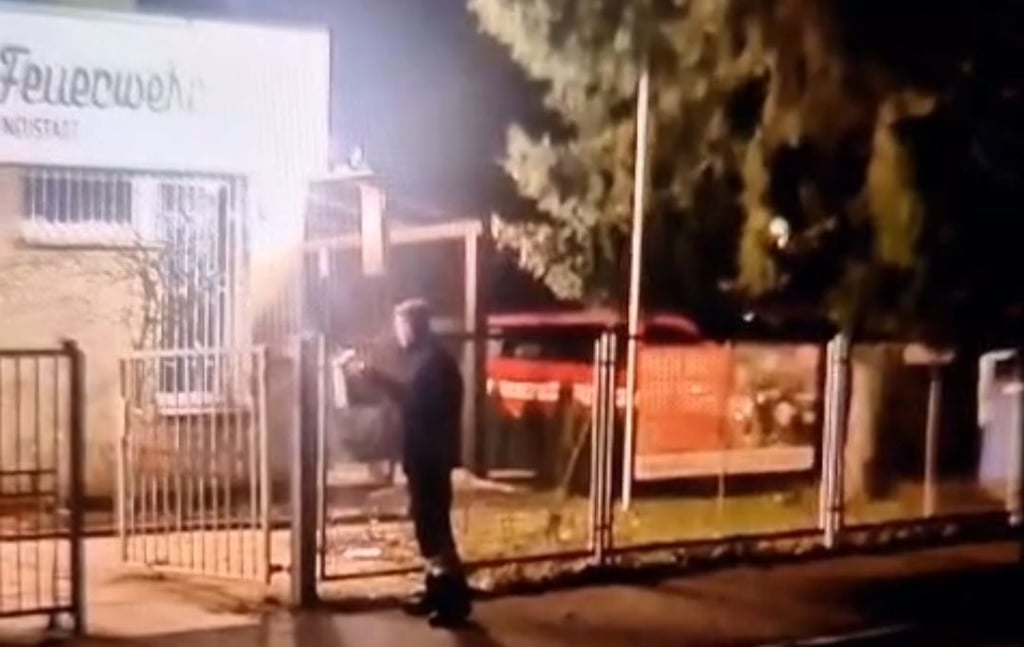 Hier steckt der Feuerwehrmann den Böller in den Briefkasten der Freiwilligen Feuerwehr Halle-Neustadt.