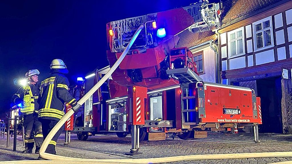 Feuerwehrleute löschen einen brennenden Dachstuhl in der Winckelmannstraße in Stendal.
