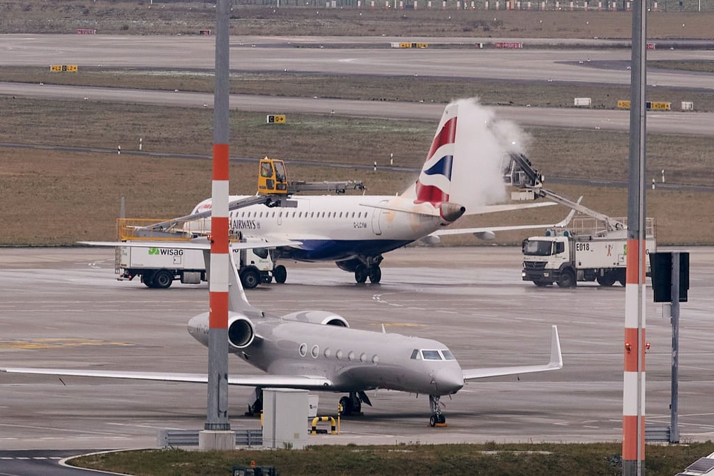 Ein Flugzeug wird am Flughafen BER vom Eis befreit.