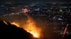 Ein Hubschrauber wirft Wasser auf das brennende Sunset Fire in den Hollywood Hills.