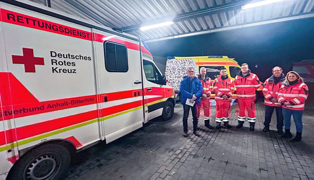 Die neue Mannschaft der Johanniter in Bitterfeld übernimmt Verantwortung – im Hintergrund ein DRK- und ein Johanniter-Fahrzeug.