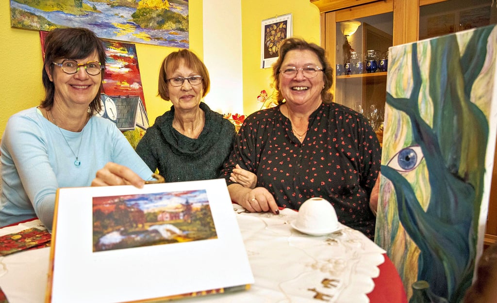 Ehemalige Schüler aus Mosigkau beim Wiedersehenstreffen mit ihrer Lehrerin Gudrun Völker (Mitte). Carola Martinus (r.) und Birgit Körting-Bauer (l.) bekamen als 13-Jährige ihre nur zehn Jahre ältere Klassenlehrerin . Das Bild vom Luisium wurde von Gudrun Völker gemalt und zum Klassentreffen verlost .