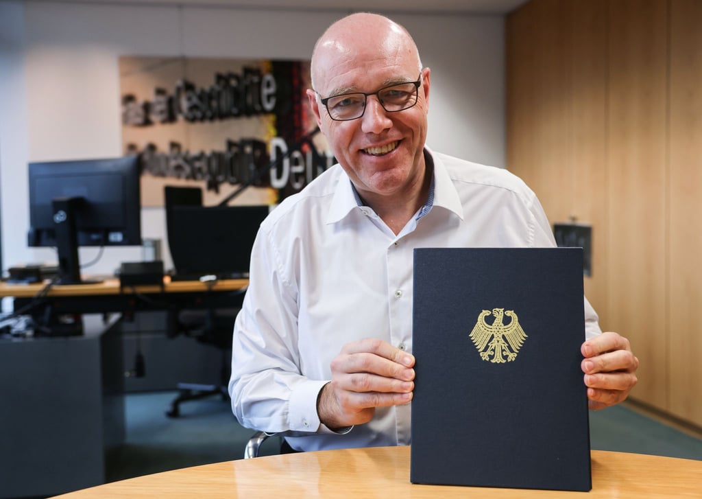 Der Präsident des Hauses der Geschichte, Harald Biermann, zeigt die Mappe mit der „Zeitenwende“-Rede von Olaf Scholz.
