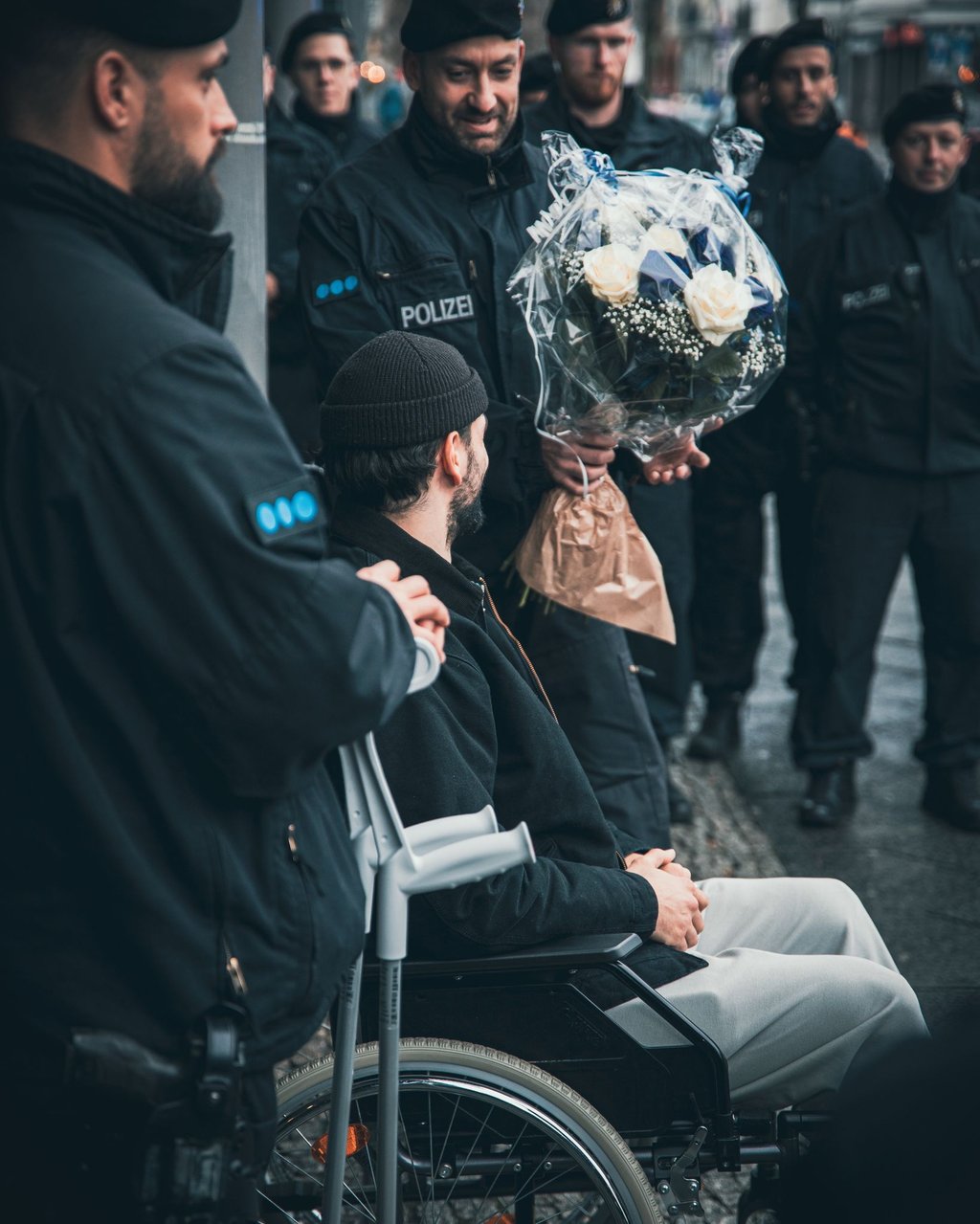 Verletzter Berliner Polizist wird von Kollegen vor dem Krankenhaus begrüßt.