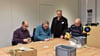 Tobias Rein, Sven Herrmann und Andreas Röhmer (von links) mit Gruppenleiter Gerhard Unger (stehend) beim Verpacken von Sämereien.