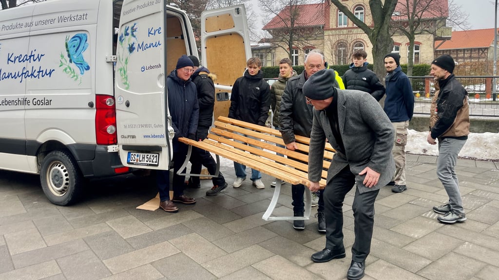 Mitglieder der Wernigeröder Stadtwerkestiftung und Schüler des Gymnasiums Wernigerode stellen neue Bänken auf dem Schulhof des Gebäudes am Heltauer Platz auf.