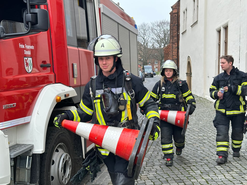 Feuerwehrleute in Stendal sicherten während des Einsatzes im Hotel Schwarzer Adler die Straße Kornmarkt ab.