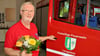 Rainer Henze  an einem Fahrzeug der Feuerwehr Lengefeld mit dem Blumenstrauß der Woche. Der Strauß wurde von der Blumenboutique Meinhardt in Sangerhausen zur Verfügung gestellt. 