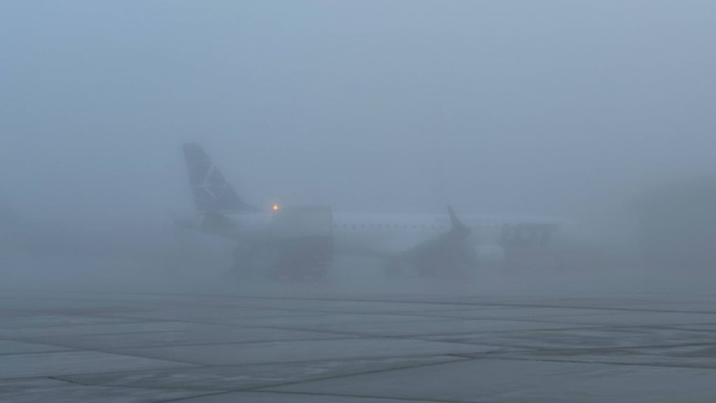 Ein Flugzeug steht im Nebel.