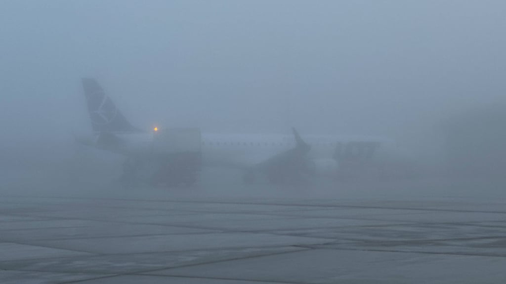 Ein Flugzeug steht im Nebel.