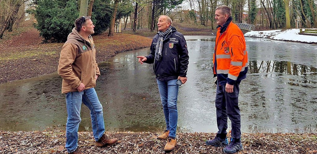 Am Teich in Osterweddingen spricht Jörg Methner (M.) mit Christian Schäfer von der Baumunion (l.) und einem Mitarbeiter des Bauhofes über die Sanierung.