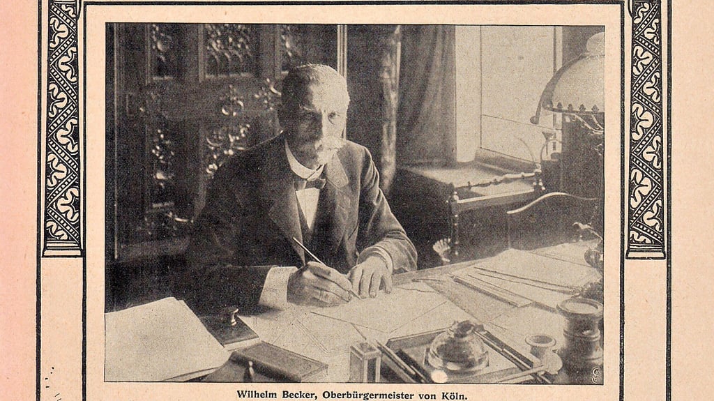 Für eine Illustrierte hat sich der 67-jährige Kölner Oberbürgermeister Wilhelm Becker bezeichnend als erster Diener der Stadtverwaltung inmitten seiner Amtsgeschäfte an seinem Schreibtisch 1902 fotografieren lassen.