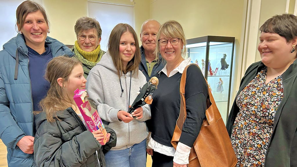 Frederike Spanjer (vierte von links) überreicht Anne Bremer (zweite von rechts) die gestaltete Barbie-Puppe.