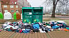 Textilien liegen verstreut um Altkleidercontainer am Nettomarkt in der Nähe des Salzwedels Bahnhofs  herum. 