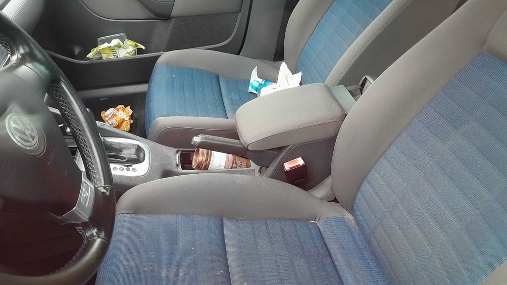 Schokoladenreste und eine Getränkepackung liegen im Innenraum des Autos am BER.