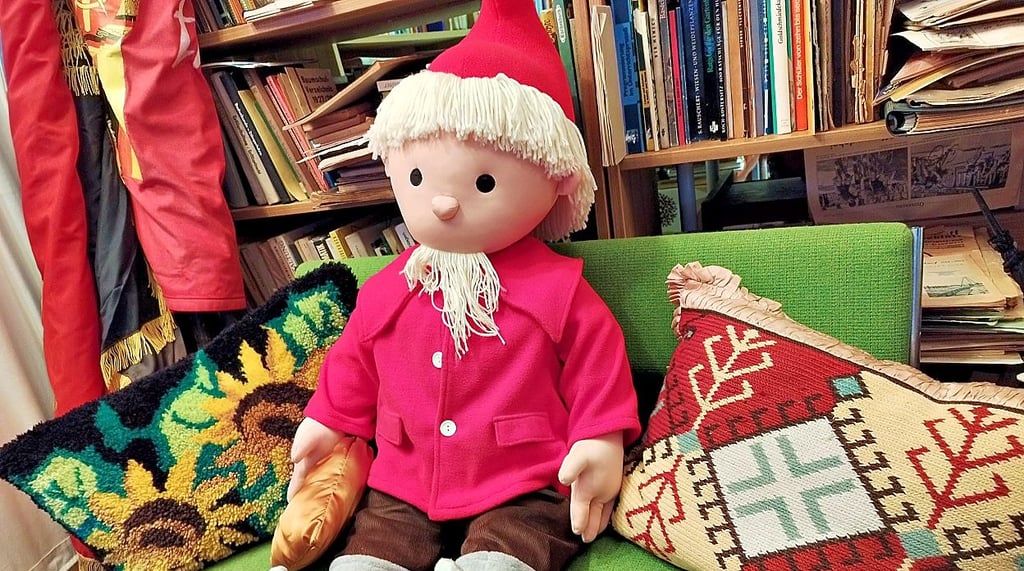 Das Sandmännchen sitzt im DDR-Museum auf einem kleinen Sofa.