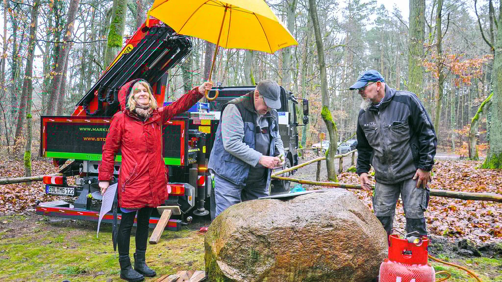 Jörg Fliege (Mitte) und Dirk Sabitzer bereiten am Mittwoch, 29. Januar, den Findling auf Barsberge bei Seehausen (Altmark) für die Namenstafel vor. Hier mit Archivpflegerin Cornelia Krainz-Eilrich.
