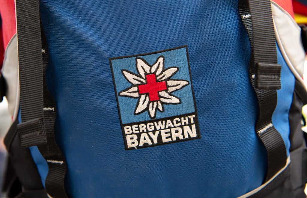 Das Logo der Bergwacht ist an einem Rucksack zu sehen. Bei Oberstdorf musste die Bergwacht nun einen Mann retten, der ohne richtige Ausrüstung und Erfahrung zwei Nächte in den Bergen verbrachte. (Archivfoto-Illustration)