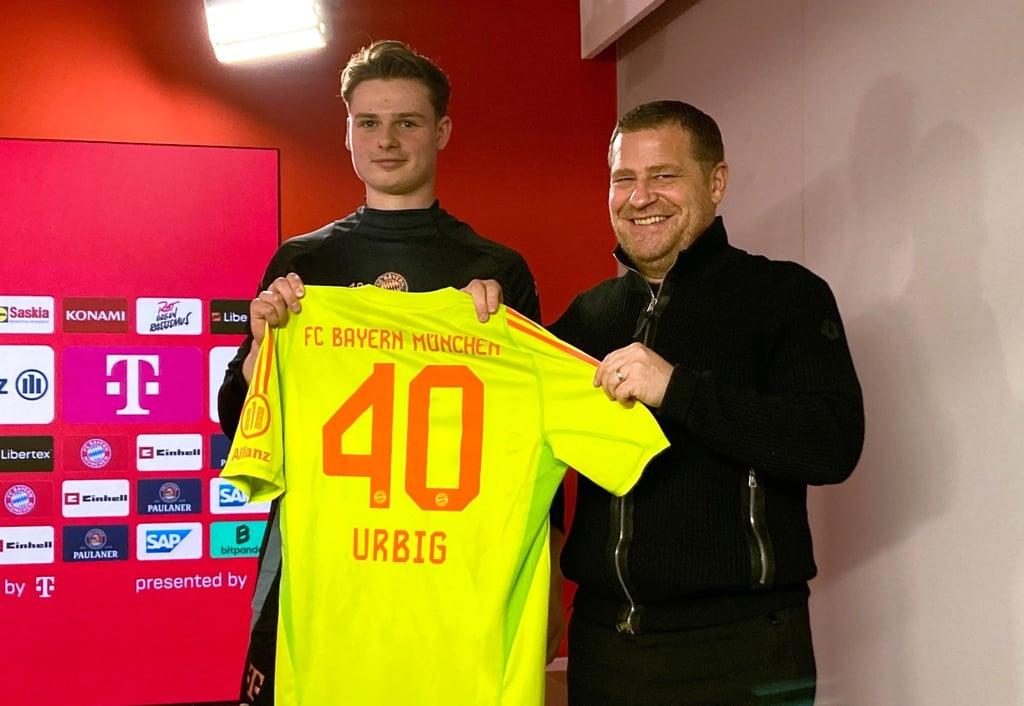 Jonas Urbig (l) präsentiert das Bayern-Trikot mit der Nummer 40 bei seiner Vorstellung mit Sportvorstand Max Eberl.