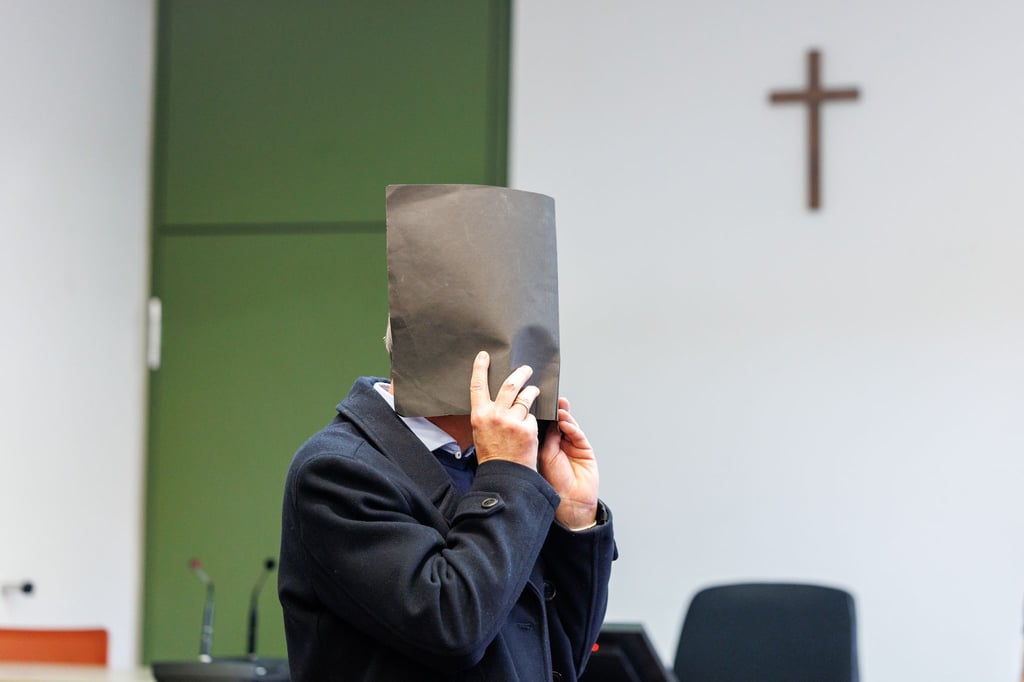 Der Angeklagte versteckte zu Prozessbeginn sein Gesicht. Er bestreitet die Vorwürfe.