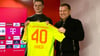 Jonas Urbig (l) präsentiert das Bayern-Trikot mit der Nummer 40 bei seiner Vorstellung mit Sportvorstand Max Eberl.