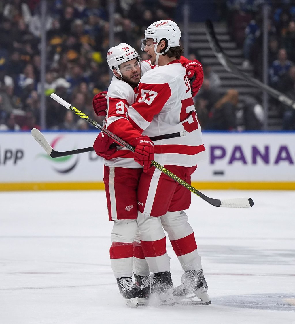Moritz Seider (re.) feiert mit Alex DeBrincat den Siegtreffer in Vancouver - den sechsten Sieg in Serie mit den Detroit Red Wings.