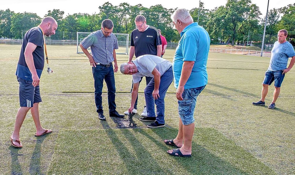 Fußball-Landespräsident Holger Stahlknecht (Mi.) hat sich bei Vereinen für einen neuen Kunstrasenplatz – auf dem Bild für die Sanierung in Piesteritz – stark gemacht. Gräfenhainichen kämpft noch um den Kunstrasen.