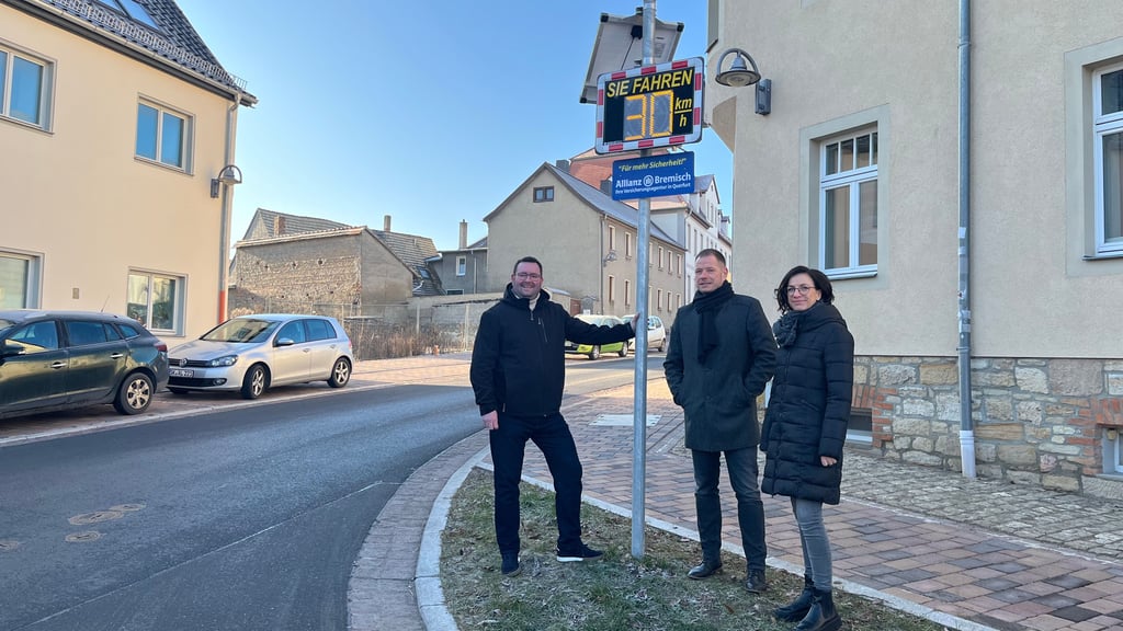 Querfurts Bürgermeister Andreas Nette (v.l.) mit René und Kathrin Bremisch an der neuen Messtafel am Freimarkt/Ecke Bäckerstraße.