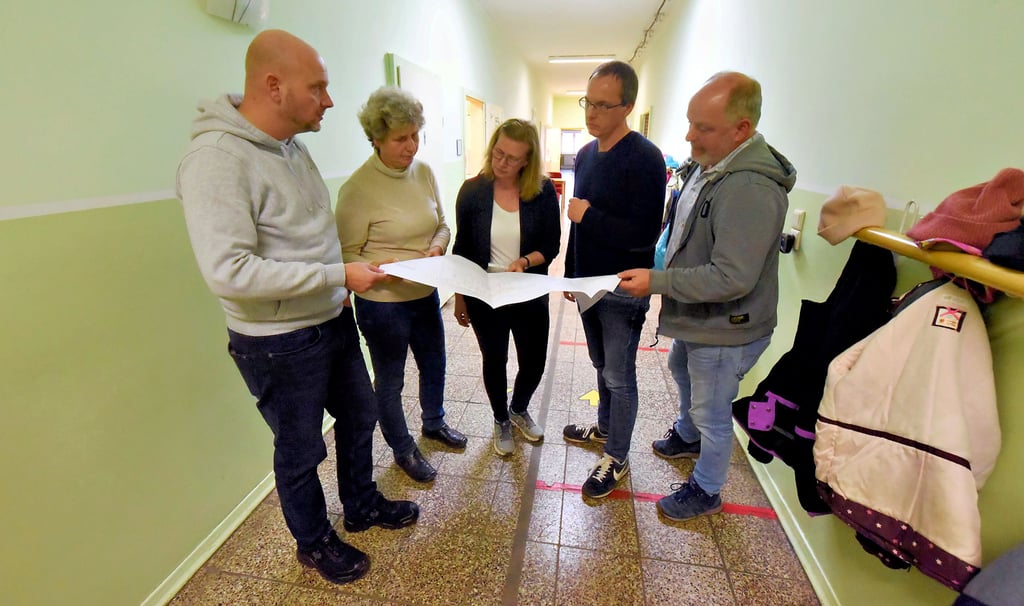 Bauamtsleiter Maik Kuhn (von links), Hortleiterin Heike Baatz, Schulleiterin Anne Hoffmann, Planer Michael Zimmer und Ortsbürgermeister Jörn Mozdzanowski besprechen die Pläne.