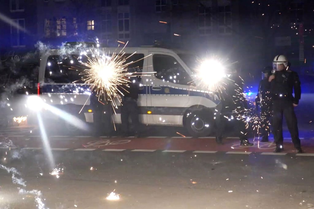 Polizeibeamte an Silvester hinter explodierendem Feuerwerk. (Archivbild)
