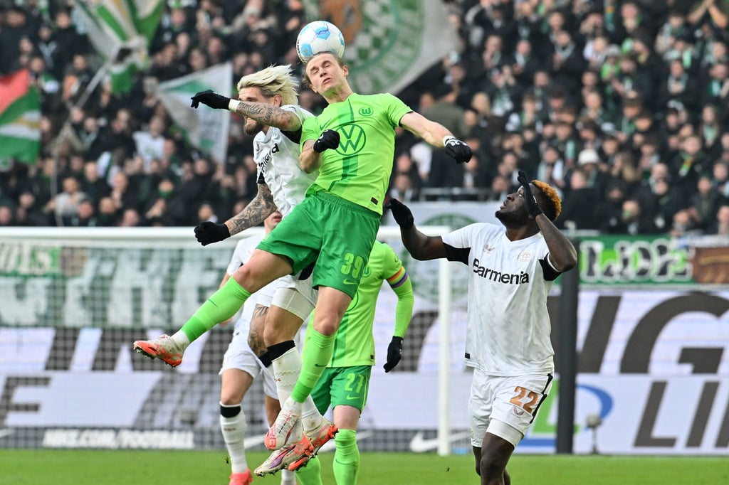 Wolfsburgs Patrick Wimmer (M) und Leverkusens Robert Andrich (l) im Kopfballduell.