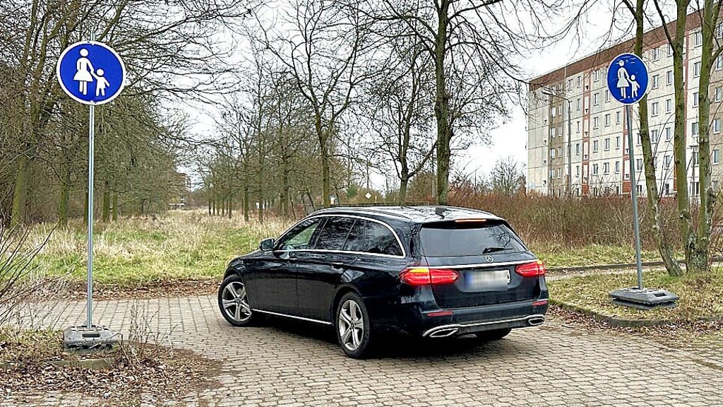 Ein Auto fährt verbotenerweise über einen Sonderweg für Fußgänger vom Parkplatz an der Hanseallee in Stendal.