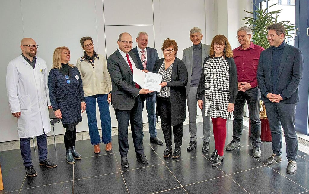 Ministerin Petra Grimm-Benne überreicht an Verwaltungsleiter André Dyrna in der Cafeteria des Klinikums den Zuwendungsbescheid über rund 30 Millionen Euro für den Bau eines Instituts- und Lehrgebäudes.