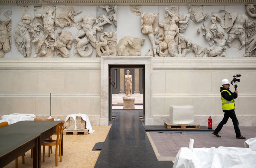Im Hintergrund steht die Figur der Göttin Athene im Saal der Hellenistischen Architektur.