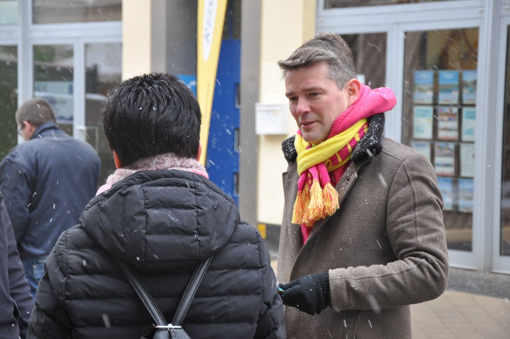 Direktkandidat Marcus Faber (FDP) kommt am Wahlkampfstand in der Breiten Straße in Stendal mit Bürgern ins Gespräch.