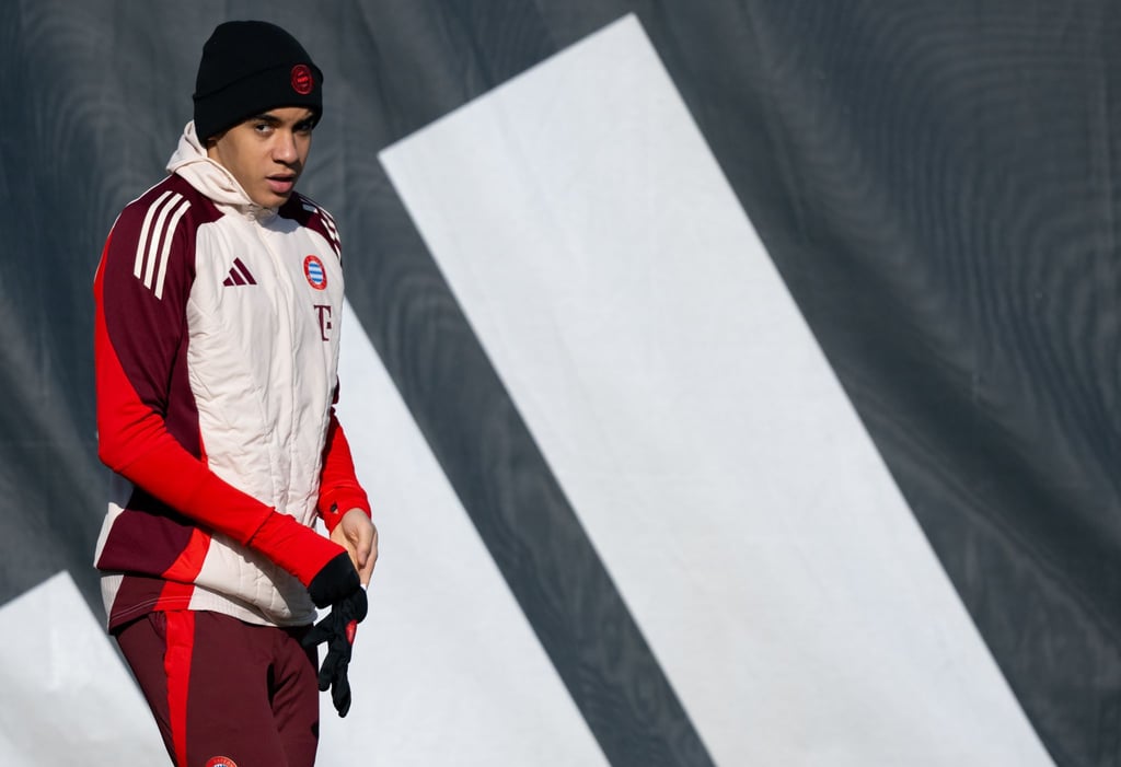 Jamal Musiala beim Training im sonnigen, aber kalten München mit Handschuhen und Mütze.