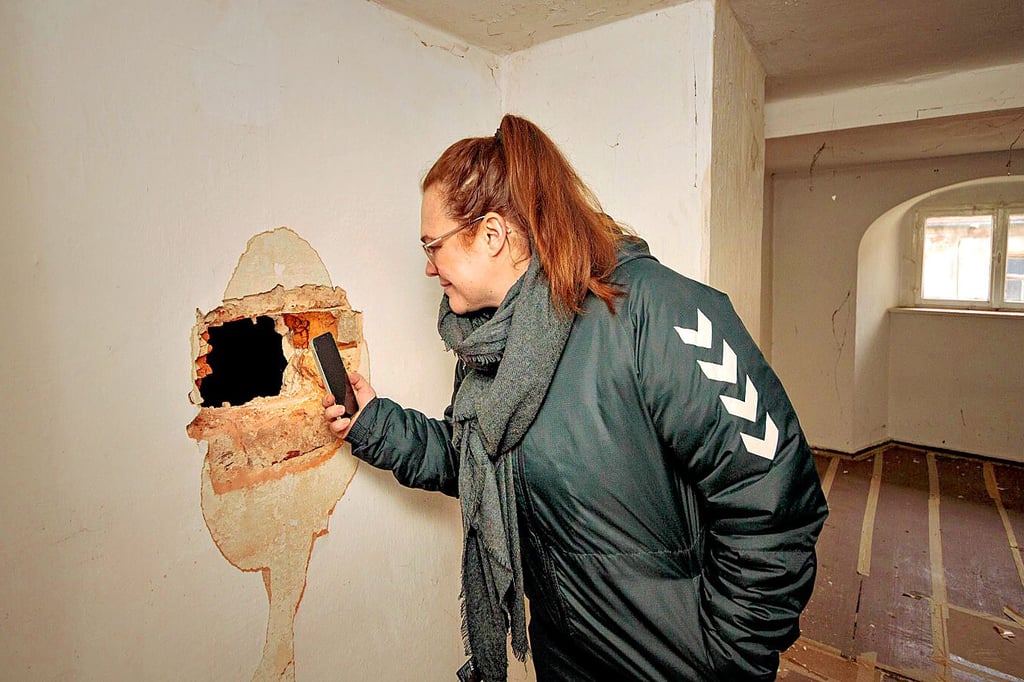 Vor der Sanierung sind im Droyßiger Schloss verborgene Räume entdeckt worden. Stefanie Kunze leuchtet in einen solchen hinein.