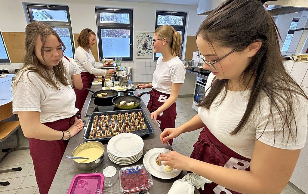 Die angehenden Erzieherinnen Jule Spangenberg (links) und Caroline Künne (rechts) bereiten gemeinsam mit Mitschülerinnen kleine Köstlichkeiten für die Gäste des Tags der offenen Tür vor.
