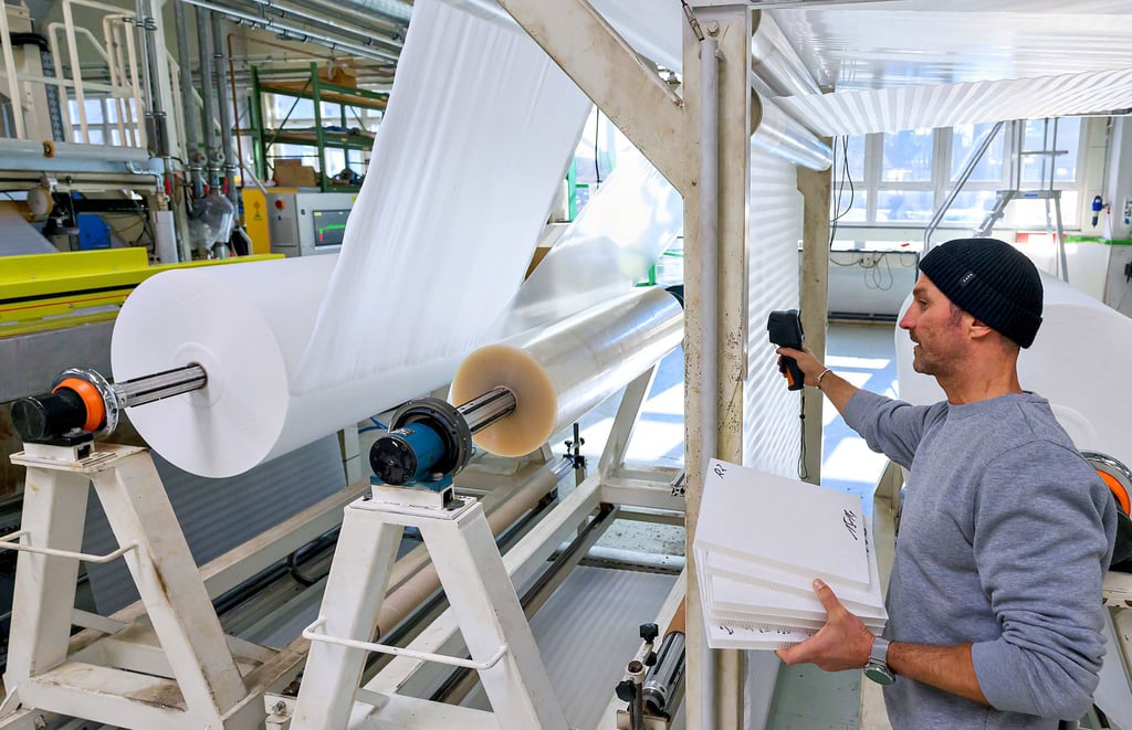 Riesige Rollen: Ein Mitarbeiter überwacht bei ThermHex die Waben-Produktion. Die Strukturen können je nach Verwendungszweck in einer Dicke von drei Millimetern bis drei Zentimetern hergestellt werden.