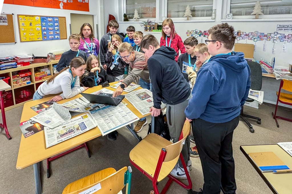 Mädchen und Jungen der 5. Klasse der Pestalozzischule Zeitz schauen mit Torsten Gerbank (Mitte), Teamleiter der MZ-Lokalredaktion Zeitz, schon am Dienstag via Laptop auf die entstehende Zeitungsausgabe vom Mittwoch.