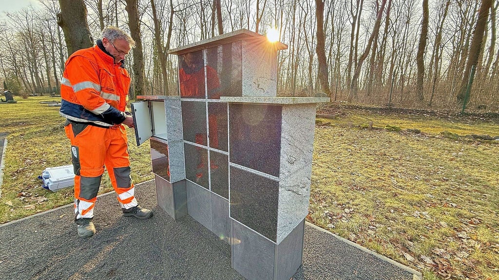 Auf dem Friedhof in Muldenstein wird auf die geänderten Bestattungswünsche reagiert. Matthias Schiebel vom Bauhof richtet die Urnenwand ein.
