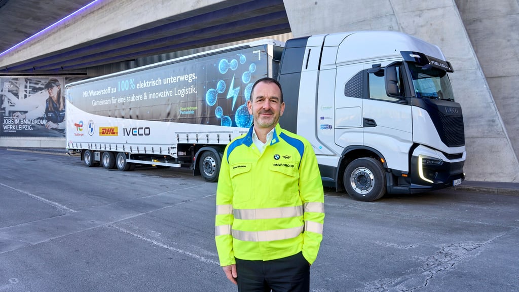 BMW-Manager Michael Nikolaides steht voreinem der beiden Wasserstoff-Lkw
