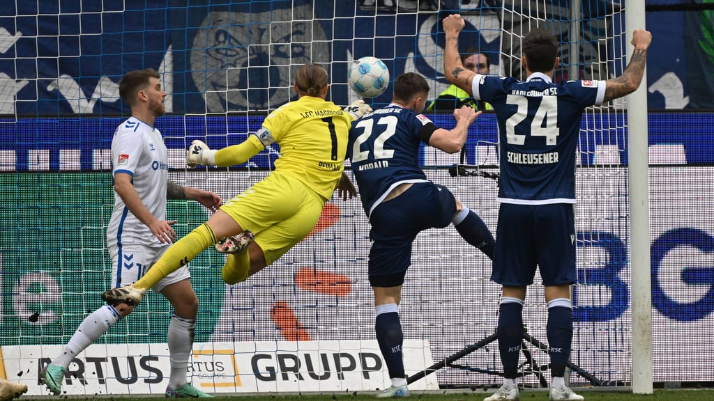 Dominik Reimann vom 1. FC Magdeburg kann das Gegentor zum 1:2 des Karlsruher SC durch Christoph Kobald nicht mehr verhindern.