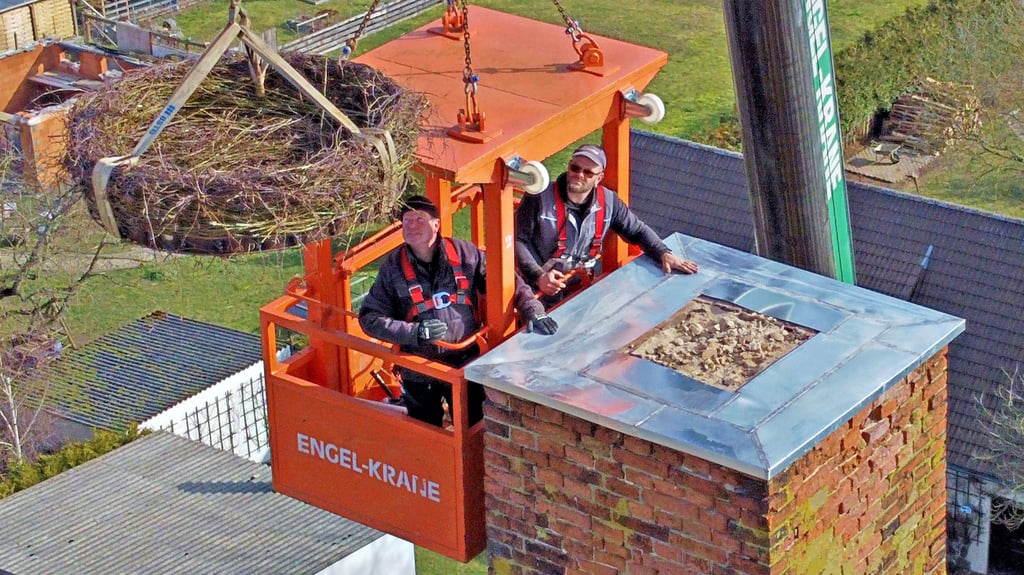 In luftiger Höhe brachten Denny Raab (li.) und Robert Ogrodowzyk das neue Storchennest auf dem Hohenziatzer Schornstein in Position.