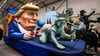 Einer der Wagen im Kölner Rosenmontagszug zeigt US-Präsident Donald Trump, der die Freiheitsstatue und die Justitia am Laufband führt.