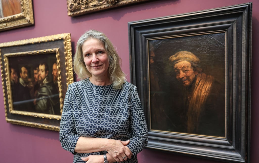 Anja Sevcik steht zwischen einem Selbstbildnis von Peter Paul Rubens unter Freunden (links) und einem Selbstbildnis von Rembrandt (rechts).